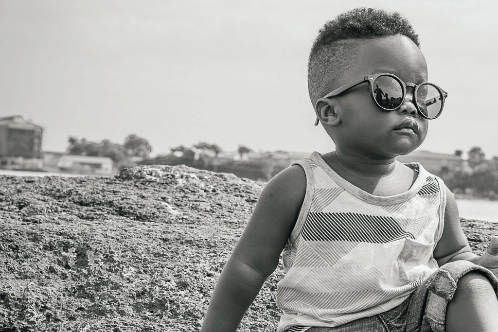 Un enfant avec des lunettes de soleil assis sur un rocher